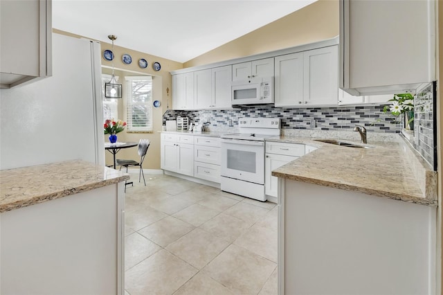 kitchen with pendant lighting, lofted ceiling, white appliances, sink, and light tile patterned flooring