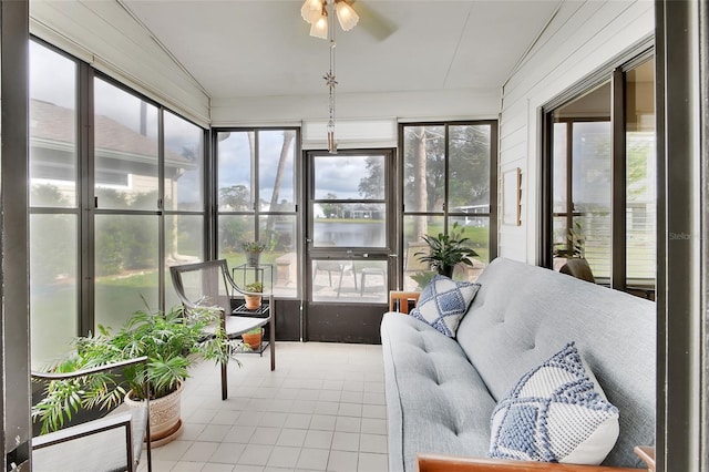 sunroom featuring ceiling fan, a healthy amount of sunlight, a water view, and lofted ceiling