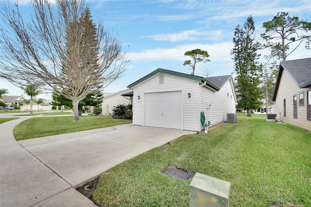 view of side of property with a yard, cooling unit, and a garage