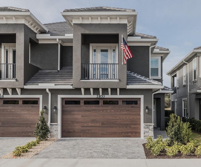 view of front of property featuring a balcony and a garage