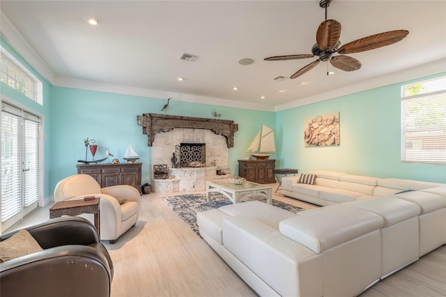 living room featuring ceiling fan, crown molding, and light hardwood / wood-style flooring