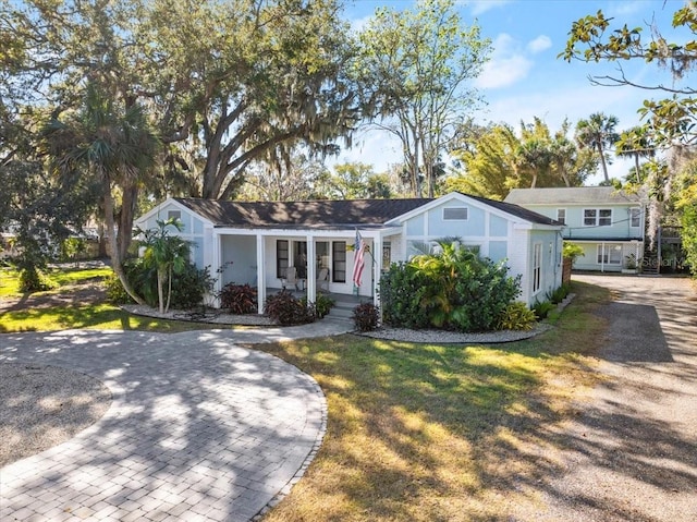 view of front facade featuring covered porch and a front lawn