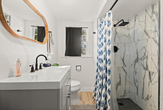 bathroom with vanity, toilet, curtained shower, and hardwood / wood-style floors