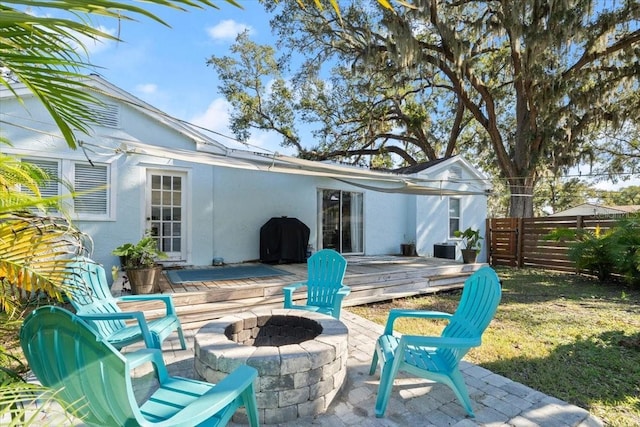 back of house featuring a wooden deck and an outdoor fire pit