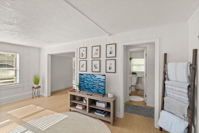 bedroom with connected bathroom and light wood-type flooring