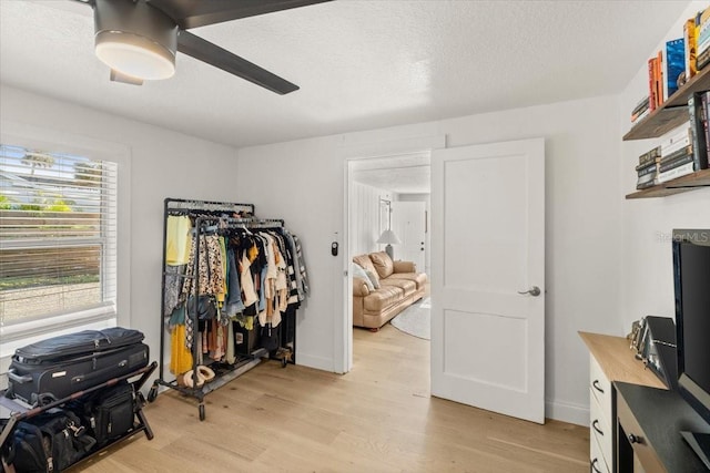 walk in closet with ceiling fan and light hardwood / wood-style floors