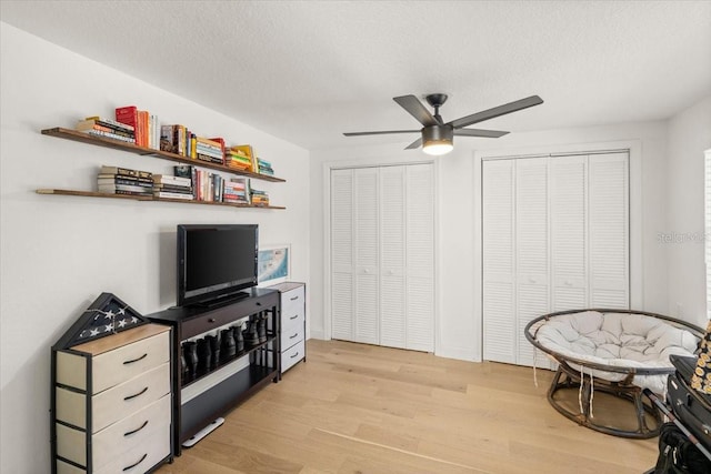 interior space featuring ceiling fan, a textured ceiling, and light wood-type flooring