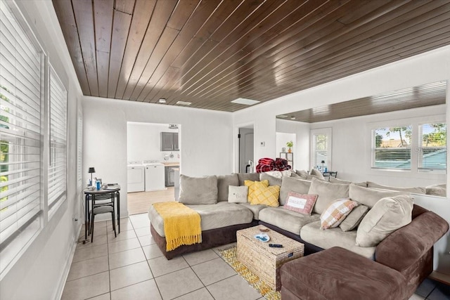 living room with washing machine and dryer, light tile patterned floors, and wooden ceiling