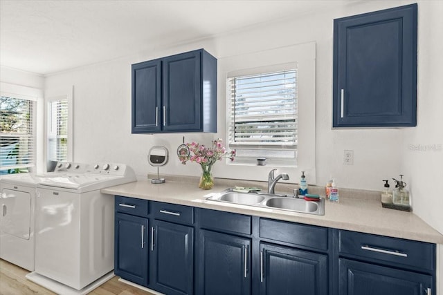 laundry area with sink, cabinets, ornamental molding, washer and dryer, and light wood-type flooring