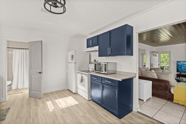 kitchen featuring white appliances, blue cabinets, and light wood-type flooring