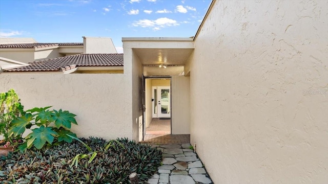 doorway to property featuring stucco siding