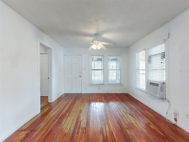 empty room with dark wood-type flooring, ceiling fan, and cooling unit