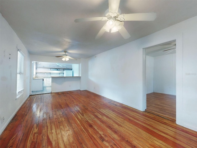 unfurnished living room featuring wood-type flooring and ceiling fan