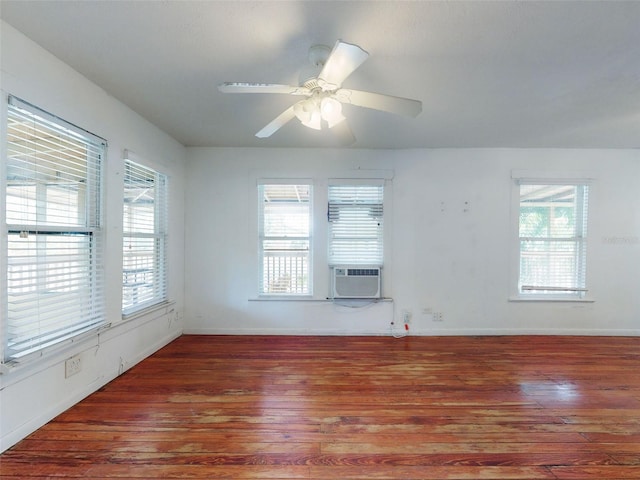 empty room with ceiling fan, a healthy amount of sunlight, and dark hardwood / wood-style floors