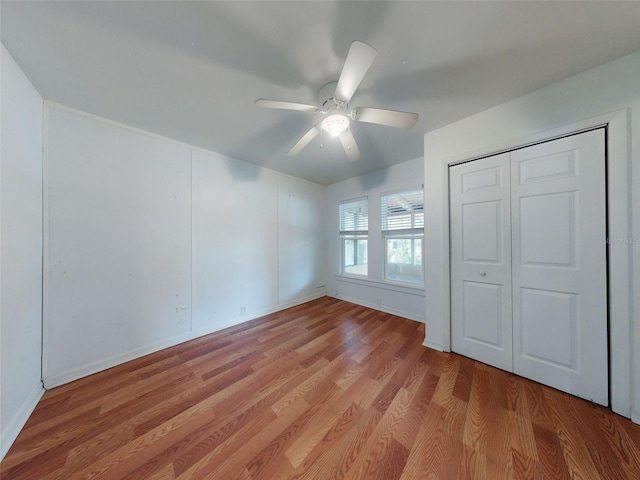 unfurnished bedroom featuring light wood-type flooring, ceiling fan, and a closet