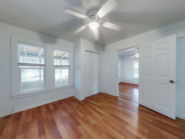 unfurnished bedroom featuring ceiling fan, light hardwood / wood-style flooring, and a closet