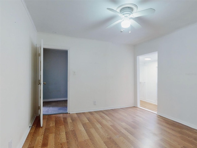 spare room with ceiling fan, light wood-type flooring, and crown molding