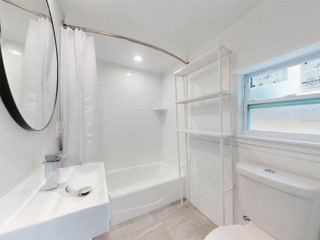 bathroom featuring toilet, shower / bath combo with shower curtain, and tile walls