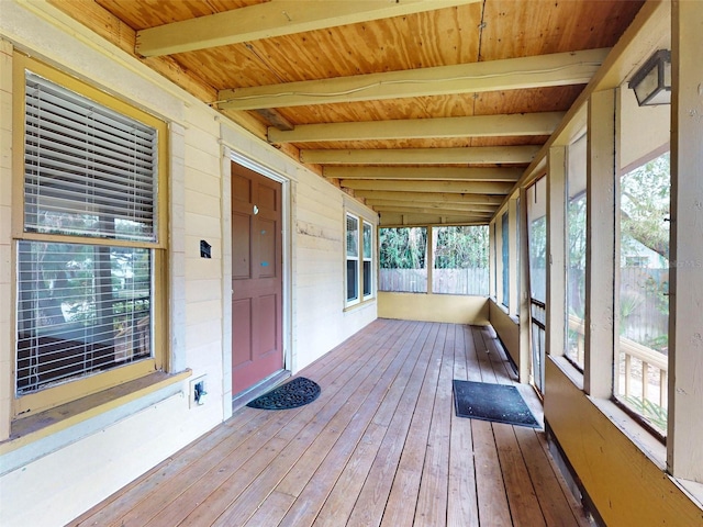 unfurnished sunroom featuring wooden ceiling and beamed ceiling