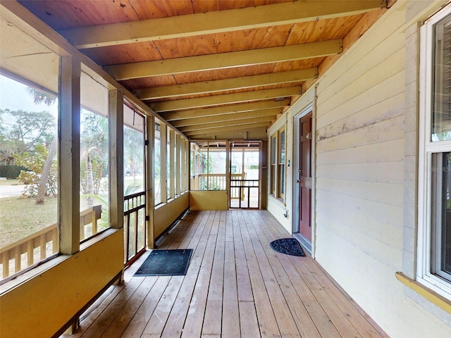 unfurnished sunroom featuring beam ceiling and wood ceiling