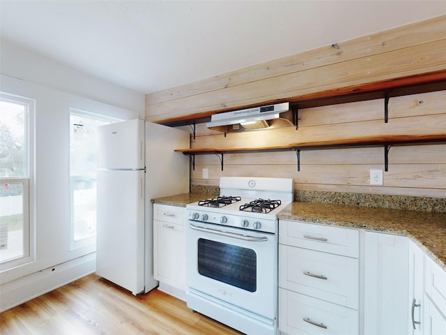 kitchen with white appliances, light hardwood / wood-style flooring, white cabinets, and light stone countertops