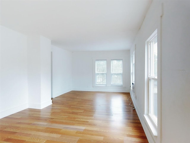 spare room with light wood-type flooring and plenty of natural light