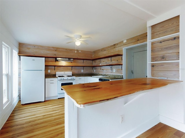 kitchen featuring sink, white cabinets, white appliances, light hardwood / wood-style flooring, and range hood