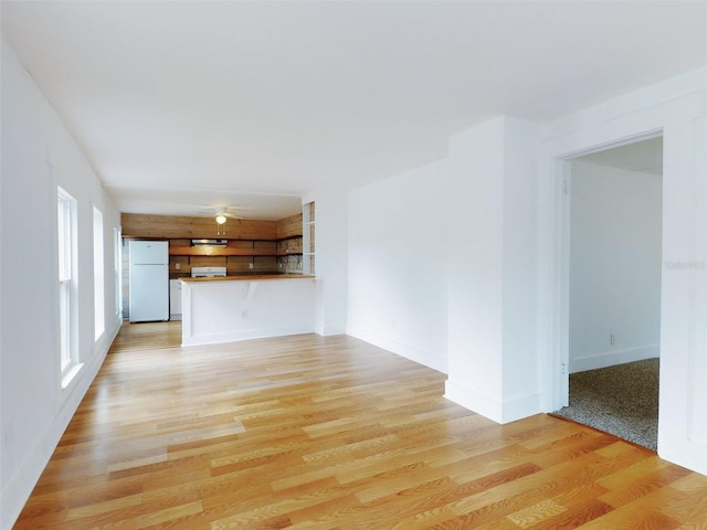 unfurnished living room featuring ceiling fan and light hardwood / wood-style flooring