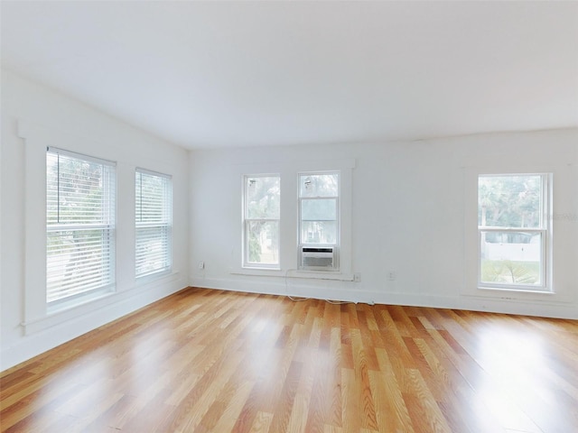 empty room with light wood-type flooring and cooling unit