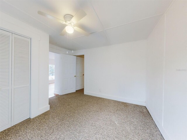 unfurnished bedroom featuring ceiling fan, a closet, and carpet