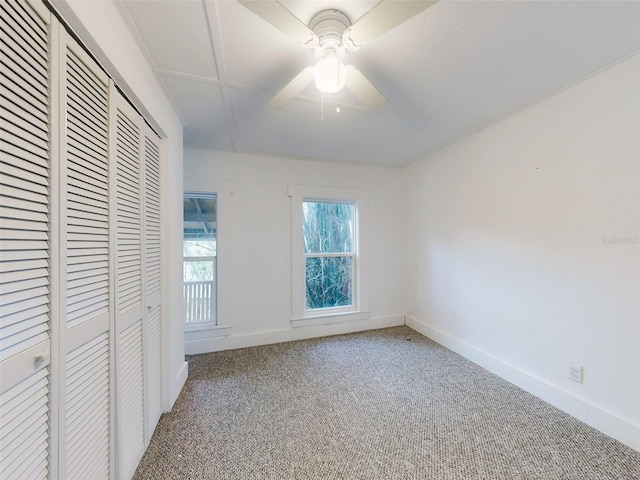 unfurnished bedroom featuring carpet floors, ceiling fan, and a closet