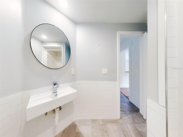 bathroom featuring sink and tile walls