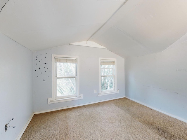 bonus room with carpet flooring and vaulted ceiling