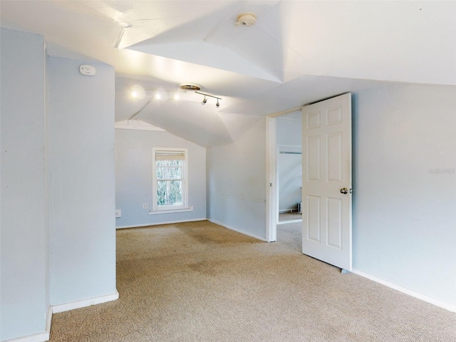 bonus room with light carpet and vaulted ceiling