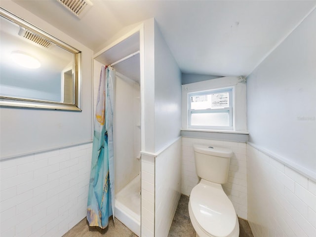 bathroom with tile walls, toilet, and a shower with shower curtain