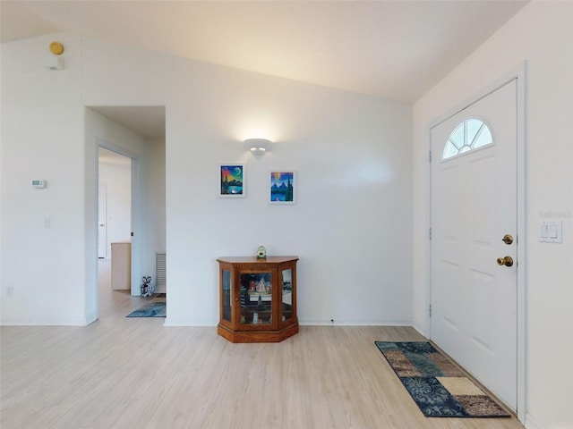 entrance foyer with lofted ceiling and light wood-type flooring