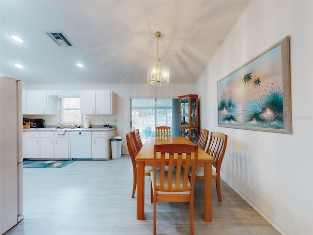 dining space with an inviting chandelier and light hardwood / wood-style floors