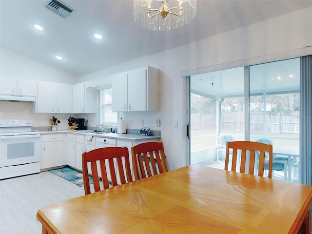 kitchen featuring white appliances, white cabinets, sink, a notable chandelier, and vaulted ceiling