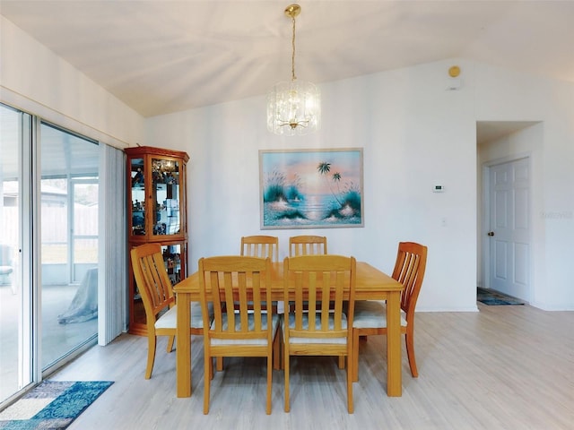 dining area featuring an inviting chandelier, lofted ceiling, and light hardwood / wood-style floors