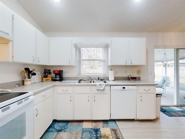 kitchen with sink, white appliances, and white cabinetry