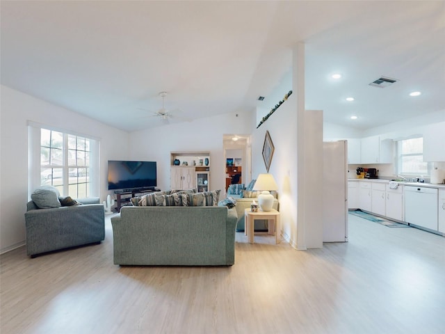 living room with lofted ceiling, ceiling fan, and light hardwood / wood-style flooring