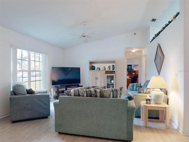 living room with ceiling fan, lofted ceiling, and light wood-type flooring