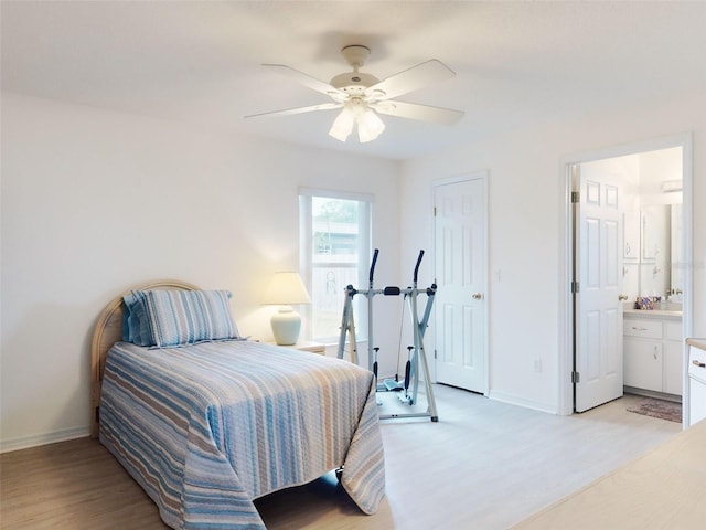 bedroom featuring ceiling fan, ensuite bathroom, and light wood-type flooring