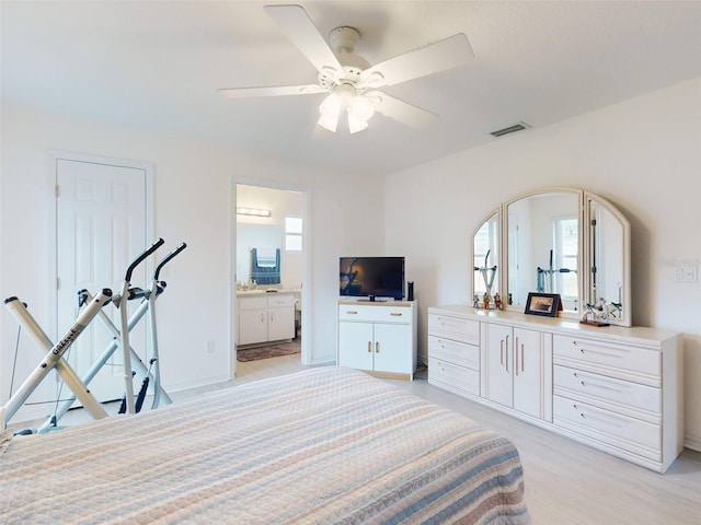 bedroom with ceiling fan, ensuite bathroom, light hardwood / wood-style flooring, and multiple windows