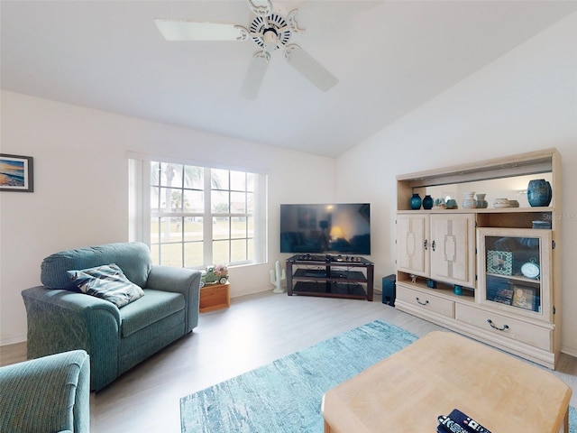 living room featuring ceiling fan, light wood-type flooring, and vaulted ceiling