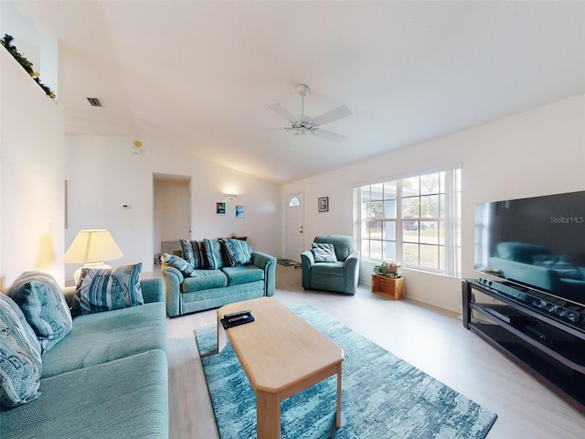 living room featuring ceiling fan, light hardwood / wood-style floors, and lofted ceiling