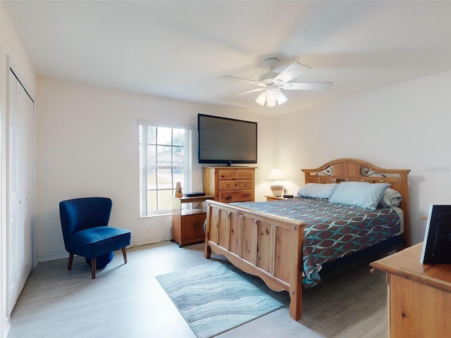 bedroom featuring ceiling fan, a closet, and light wood-type flooring