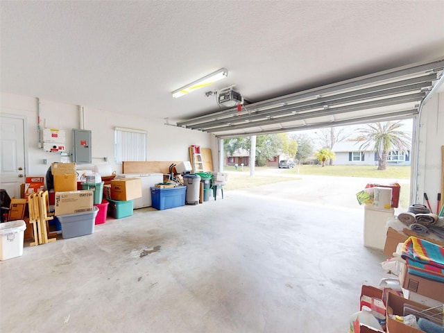 garage featuring electric panel and a garage door opener