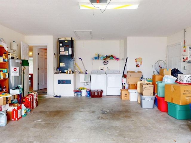 garage featuring water heater, heating unit, and independent washer and dryer