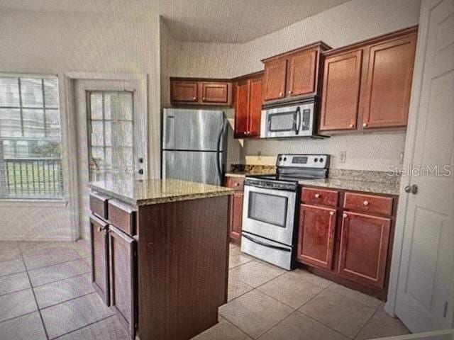 kitchen with light stone counters, light tile patterned floors, and appliances with stainless steel finishes